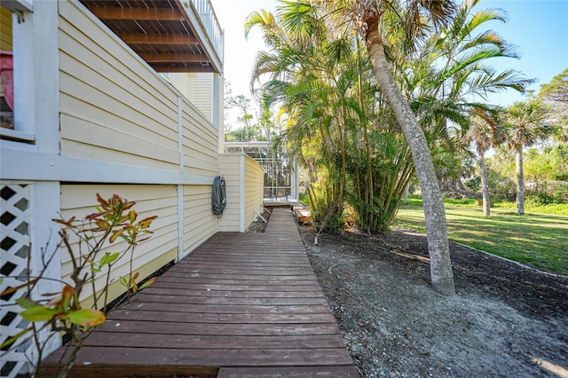 wooden deck with a yard and glass enclosure