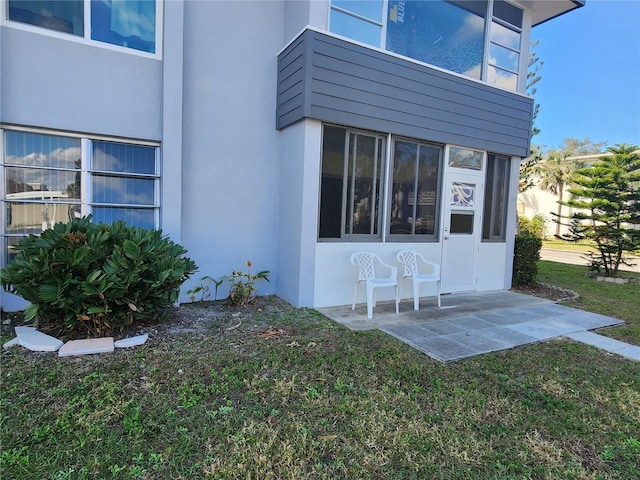 doorway to property featuring a yard and a patio area