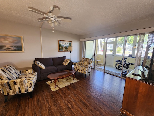 living room featuring ceiling fan, a wealth of natural light, a textured ceiling, and dark hardwood / wood-style flooring