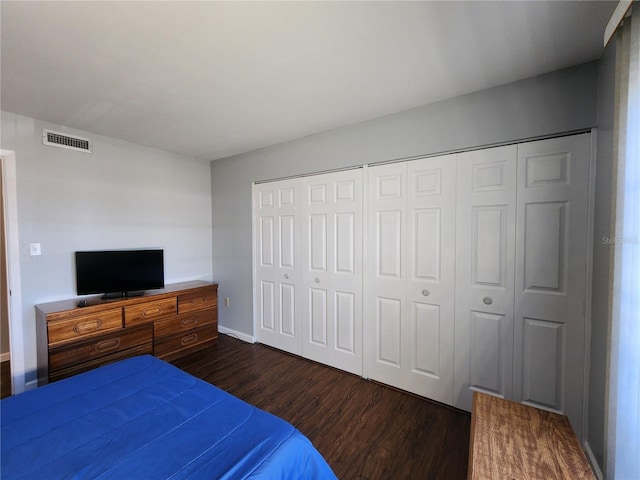 bedroom with dark hardwood / wood-style floors and a closet