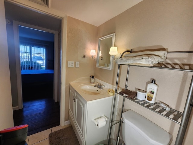 bathroom featuring vanity, toilet, and tile patterned flooring