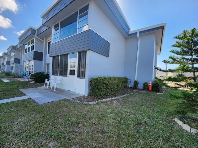 view of side of property with a lawn and a patio area