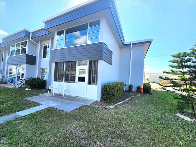 back of property with a patio and a lawn