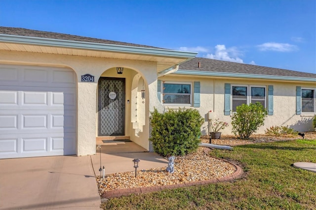 entrance to property with a garage and a lawn