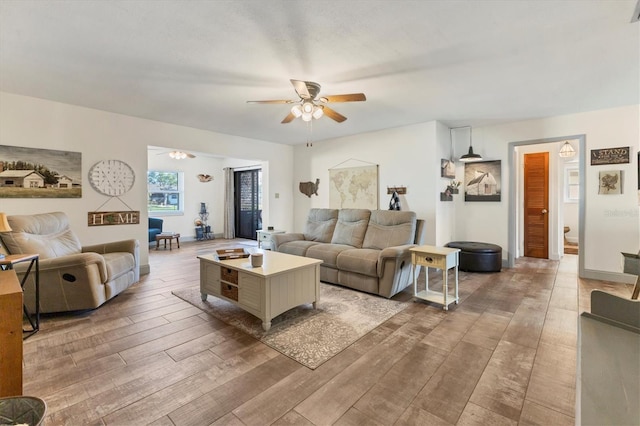 living room with ceiling fan and hardwood / wood-style floors