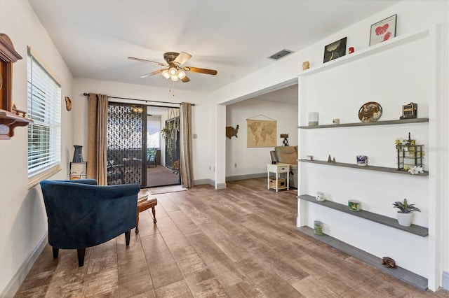 sitting room with hardwood / wood-style flooring and ceiling fan