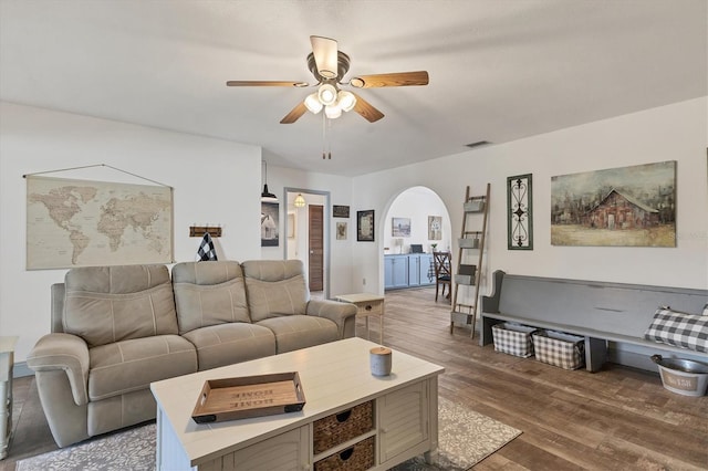 living room with dark wood-type flooring and ceiling fan