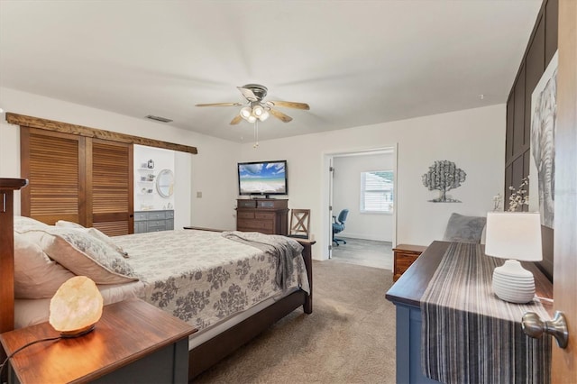 bedroom featuring ceiling fan, ensuite bathroom, and carpet floors