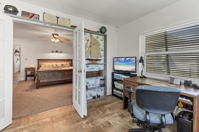 carpeted home office with french doors and ceiling fan