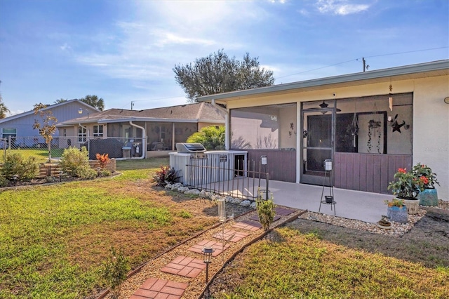 back of property featuring cooling unit, a yard, a sunroom, and a patio