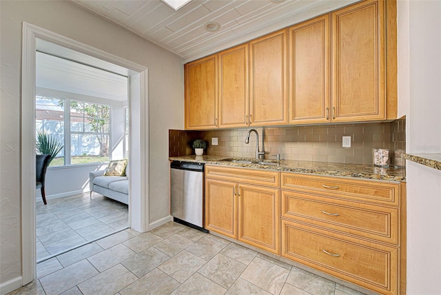 kitchen featuring light stone counters, sink, tasteful backsplash, and stainless steel dishwasher