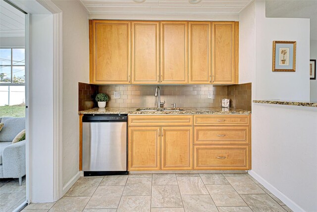 kitchen featuring sink, stainless steel dishwasher, and light stone countertops