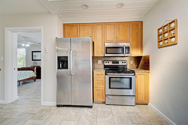 kitchen featuring backsplash, light stone countertops, and appliances with stainless steel finishes