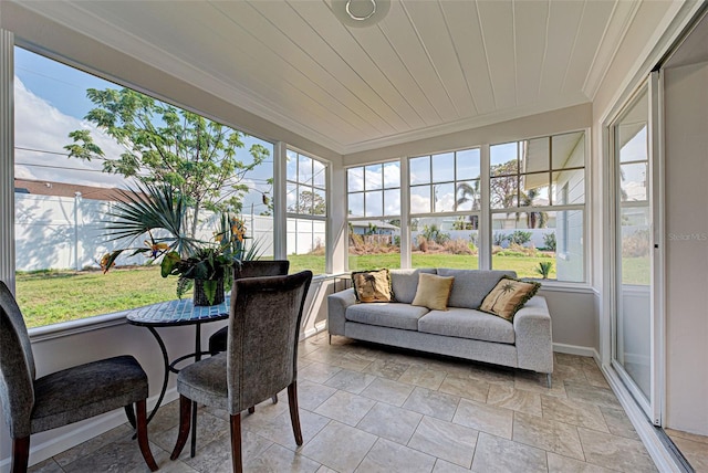 sunroom / solarium featuring a healthy amount of sunlight and wooden ceiling