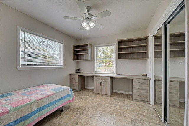 bedroom with built in desk and ceiling fan