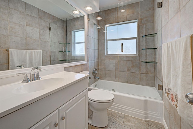 full bathroom featuring tile walls, vanity, enclosed tub / shower combo, and toilet