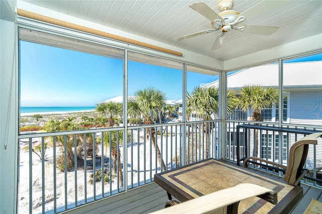 sunroom featuring a water view, ceiling fan, and a wealth of natural light