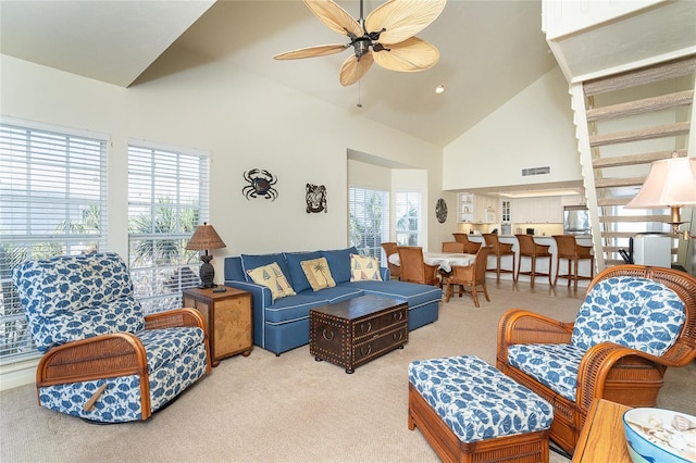 living room featuring light carpet, high vaulted ceiling, and ceiling fan