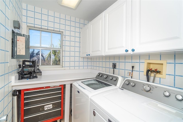 laundry area featuring cabinets, tile walls, and independent washer and dryer