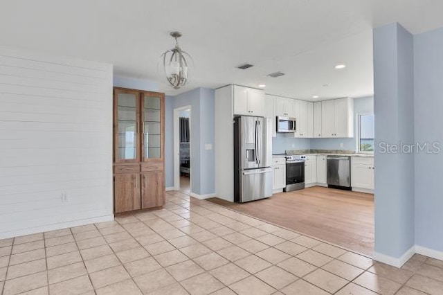 kitchen featuring white cabinetry, light tile patterned floors, pendant lighting, and stainless steel appliances