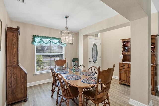 dining space with a chandelier and light hardwood / wood-style floors