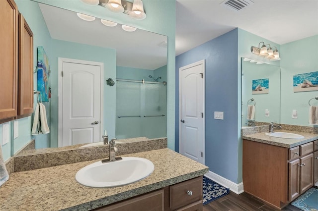 bathroom featuring wood-type flooring, an enclosed shower, and vanity