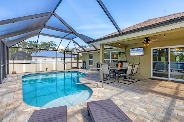 view of pool featuring a patio, ceiling fan, and glass enclosure