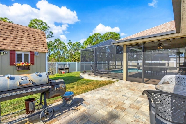 view of patio with area for grilling, a fenced in pool, and glass enclosure