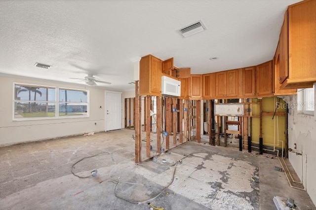 kitchen featuring ceiling fan, a textured ceiling, and a healthy amount of sunlight