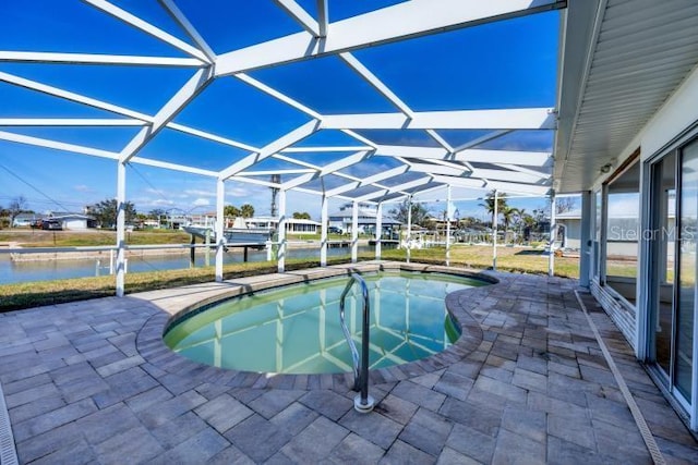 view of pool with a lanai, a patio area, and a water view