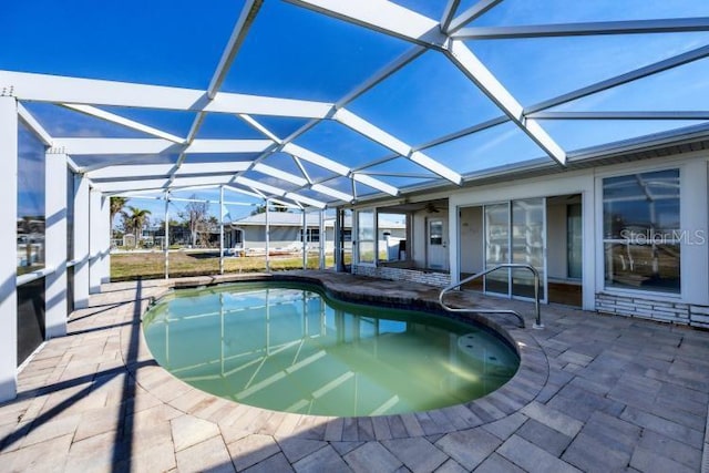 view of swimming pool featuring a patio and glass enclosure