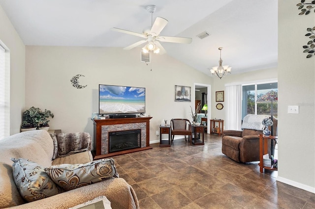 living room with lofted ceiling, a stone fireplace, and ceiling fan with notable chandelier