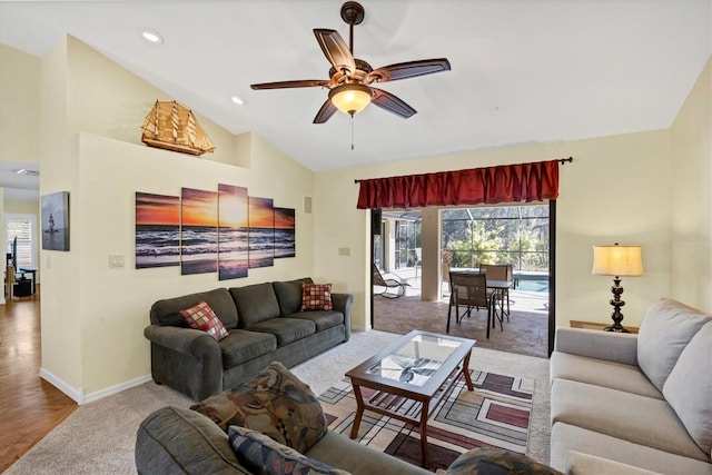 living area with a ceiling fan, a wealth of natural light, baseboards, and carpet