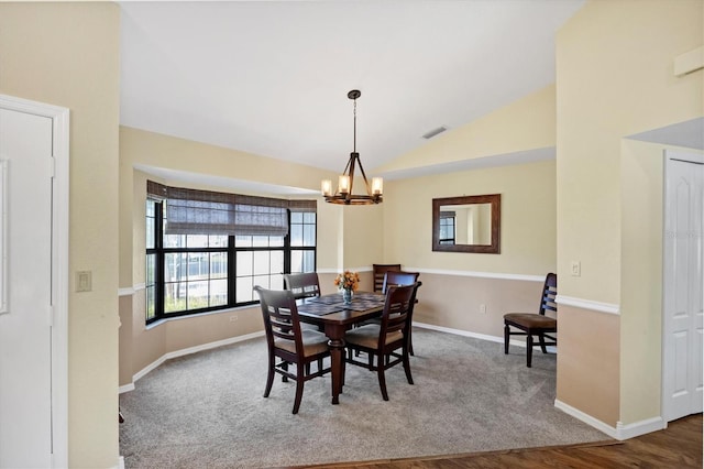 carpeted dining room with an inviting chandelier, visible vents, baseboards, and lofted ceiling