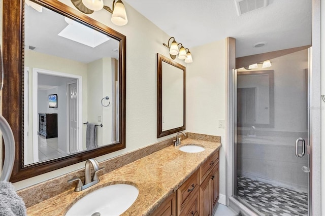 full bathroom with double vanity, visible vents, a stall shower, and a sink