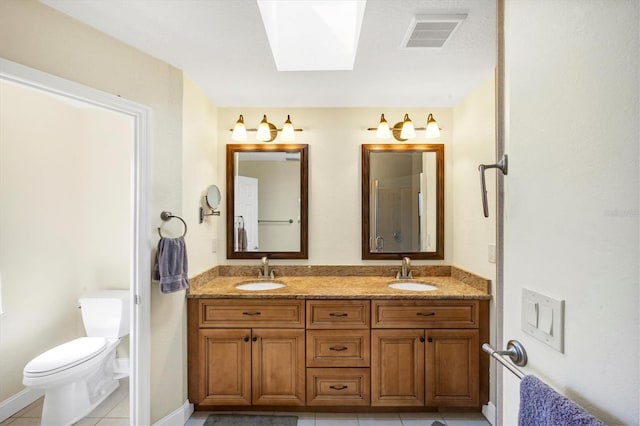bathroom featuring a skylight, tile patterned floors, visible vents, and a sink