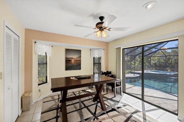 office space with a sunroom, a ceiling fan, and light tile patterned floors