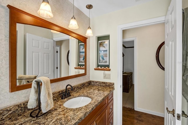 bathroom with vanity, baseboards, and wood finished floors