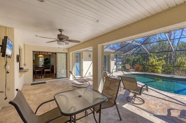 view of patio / terrace with glass enclosure, an outdoor pool, and ceiling fan