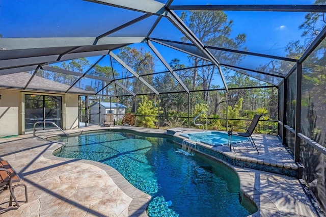 pool with a patio, an in ground hot tub, a storage unit, an outbuilding, and glass enclosure