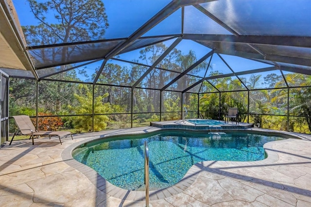 view of swimming pool with a pool with connected hot tub, a patio area, and a lanai