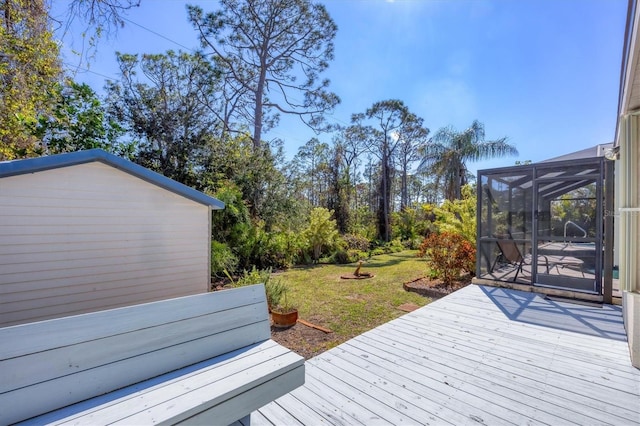 deck featuring a lawn, an outdoor structure, and a lanai