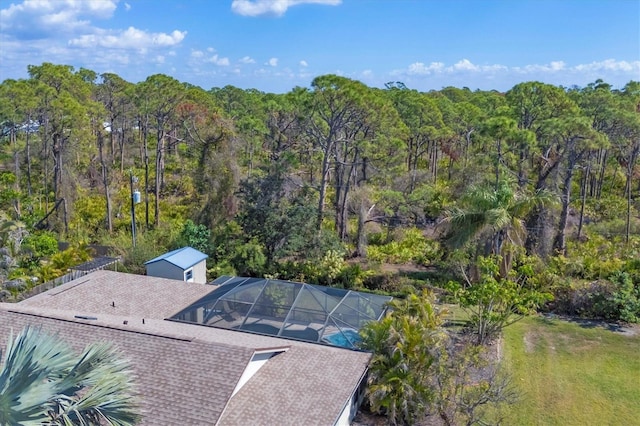 drone / aerial view with a wooded view
