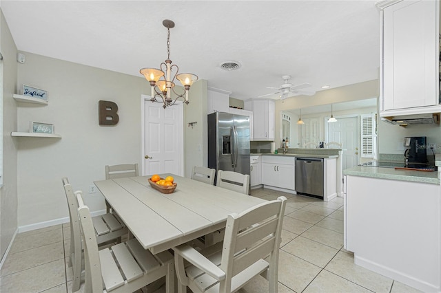 tiled dining room with sink and ceiling fan with notable chandelier