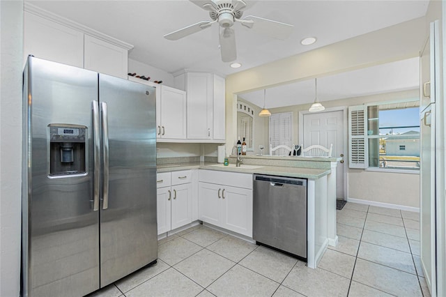 kitchen with appliances with stainless steel finishes, kitchen peninsula, and white cabinets