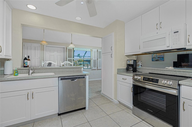 kitchen featuring sink, white cabinetry, hanging light fixtures, light tile patterned floors, and appliances with stainless steel finishes