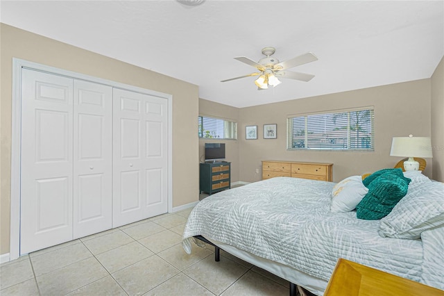 bedroom with light tile patterned floors, a closet, and ceiling fan