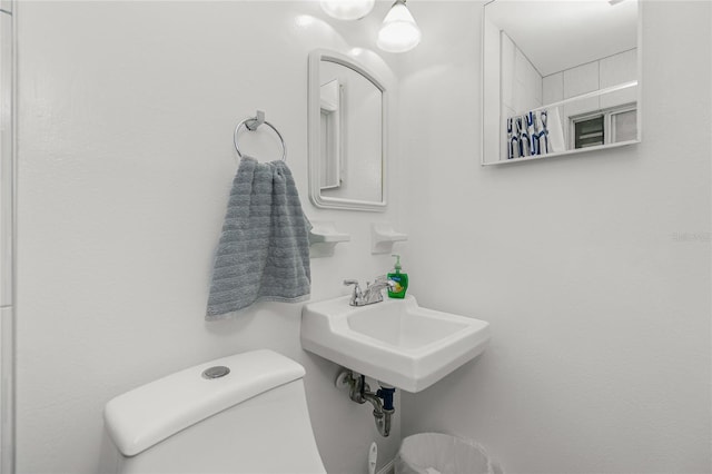 bathroom featuring sink, toilet, and a shower with shower curtain