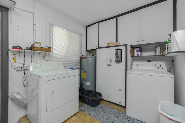 clothes washing area with cabinets, washer and clothes dryer, and water heater