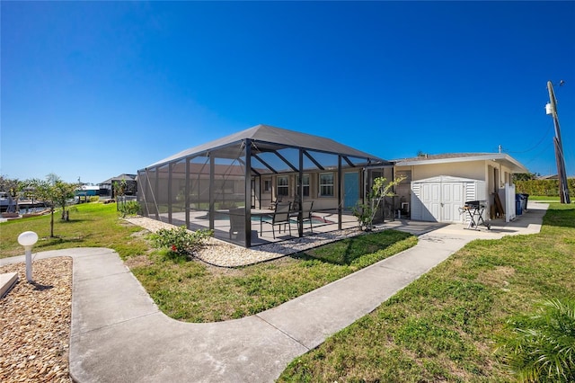 view of property's community featuring a lanai, a patio area, a lawn, and a storage unit